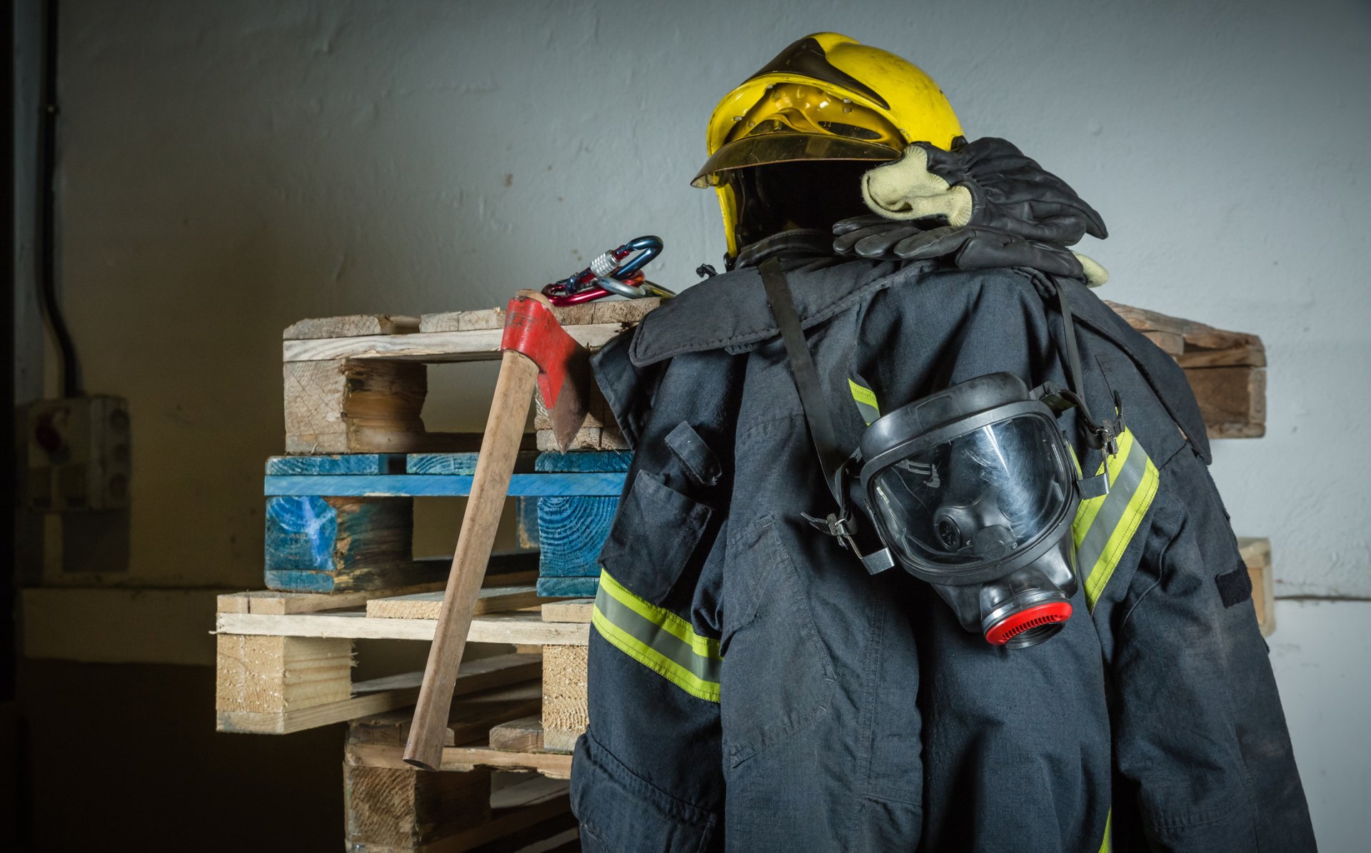 Firefighter turnout gear, including helmet, coat, gloves, and breathing mask, mounted on a form.