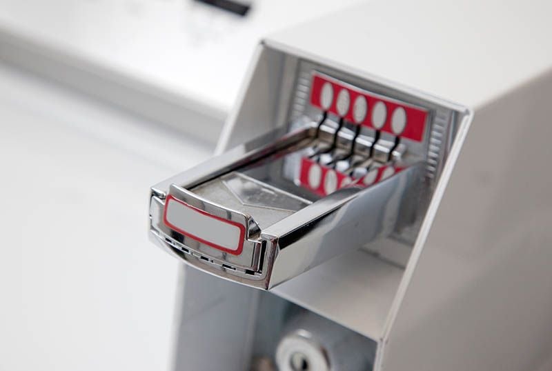 A chrome coin slide pulled out from the side of a commercial washer.