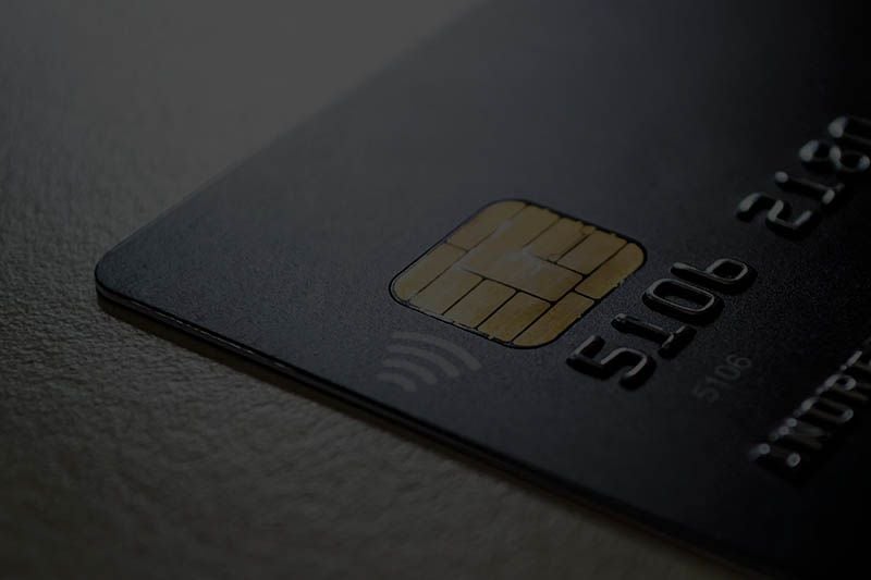 A dark chip-and-tap bank card resting on a countertop.
